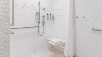 Un bagno moderno con doccia a filo pavimento, un water con portasci e un asciugamani ad aria.
