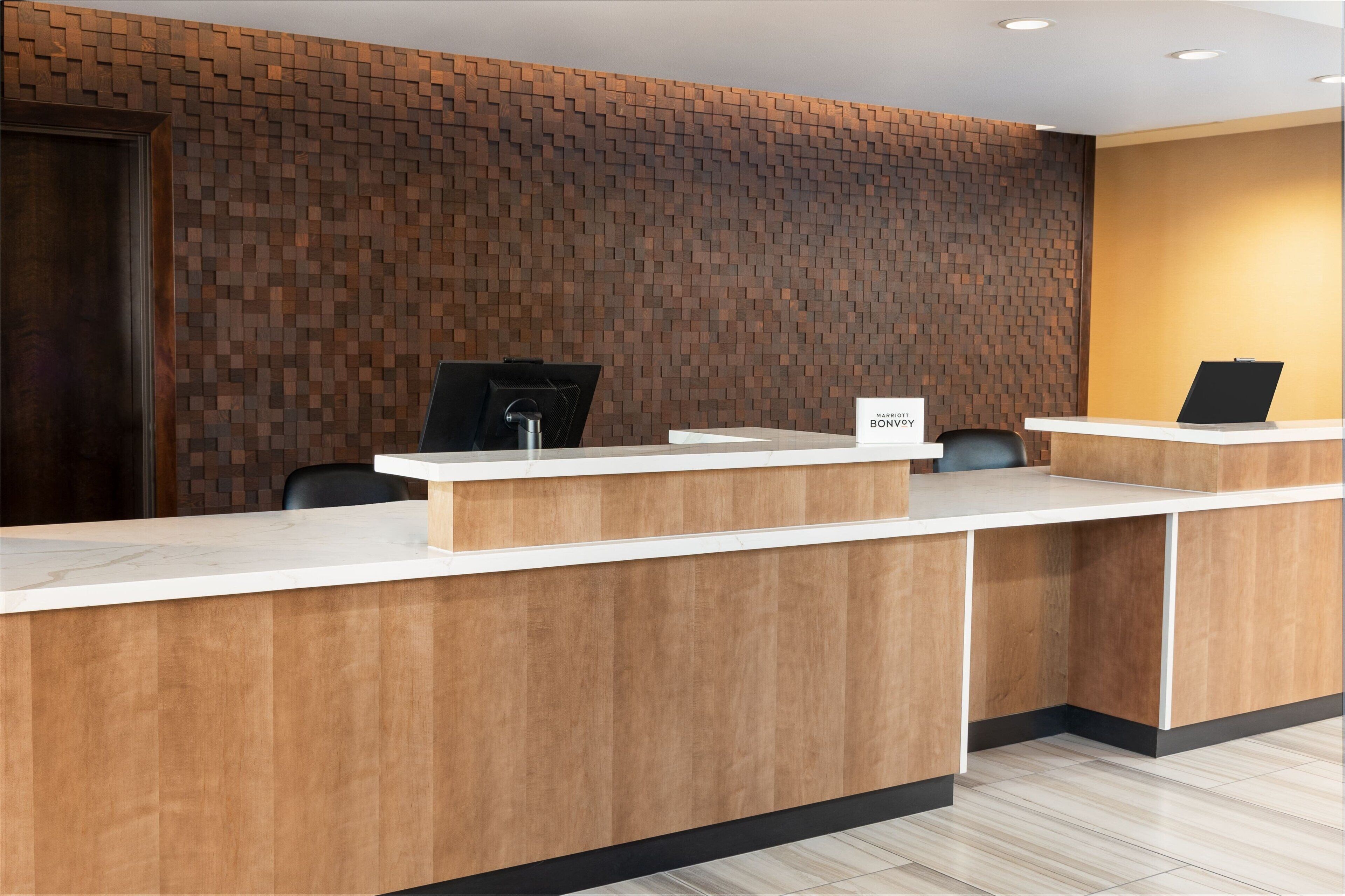 A reception desk with a wooden panel wall and a sign that reads "MARTIN BONOVO".