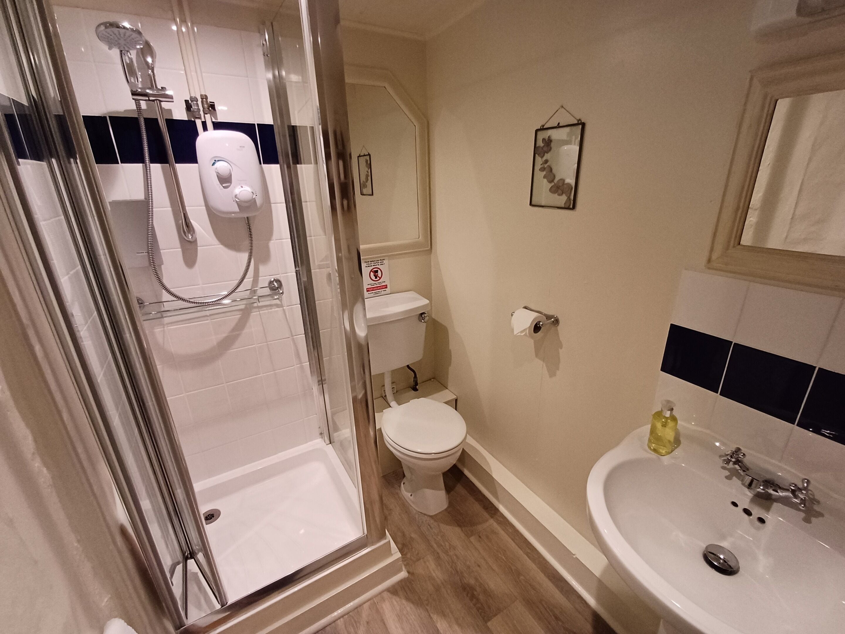 Une salle de bain avec une douche à parois de verre, des toilettes et un lavabo.