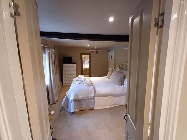 Un dormitorio con cama, cómoda, espejo y mesita de noche.