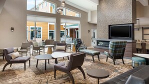 A spacious lobby with multiple seating areas, a large flat-screen TV, and a fireplace. - Residence Inn by Marriott New Haven Hamden (Hamden)