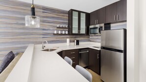 A modern kitchen with a marble backsplash, stainless steel appliances, and dark cabinetry. - Residence Inn by Marriott New Haven Hamden (Hamden)