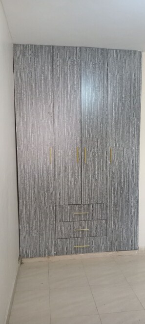 Un armario gris con tiradores dorados y una sección con espejo.