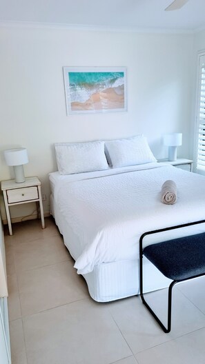 Restful retreat with a large bed, bedside table, and comfortable seating area.