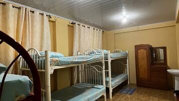 A room with bunk beds, a wooden wardrobe, and a sink.
