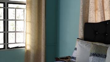 Un dormitorio con cama, cortinas y ventana.