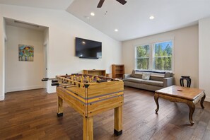 Relax in this cozy living space with a foosball table, comfortable sofa, and flat-screen TV.