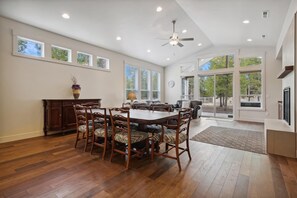Enjoy meals in this dining area with a large table and six chairs, surrounded by large windows offering views of the outdoors.