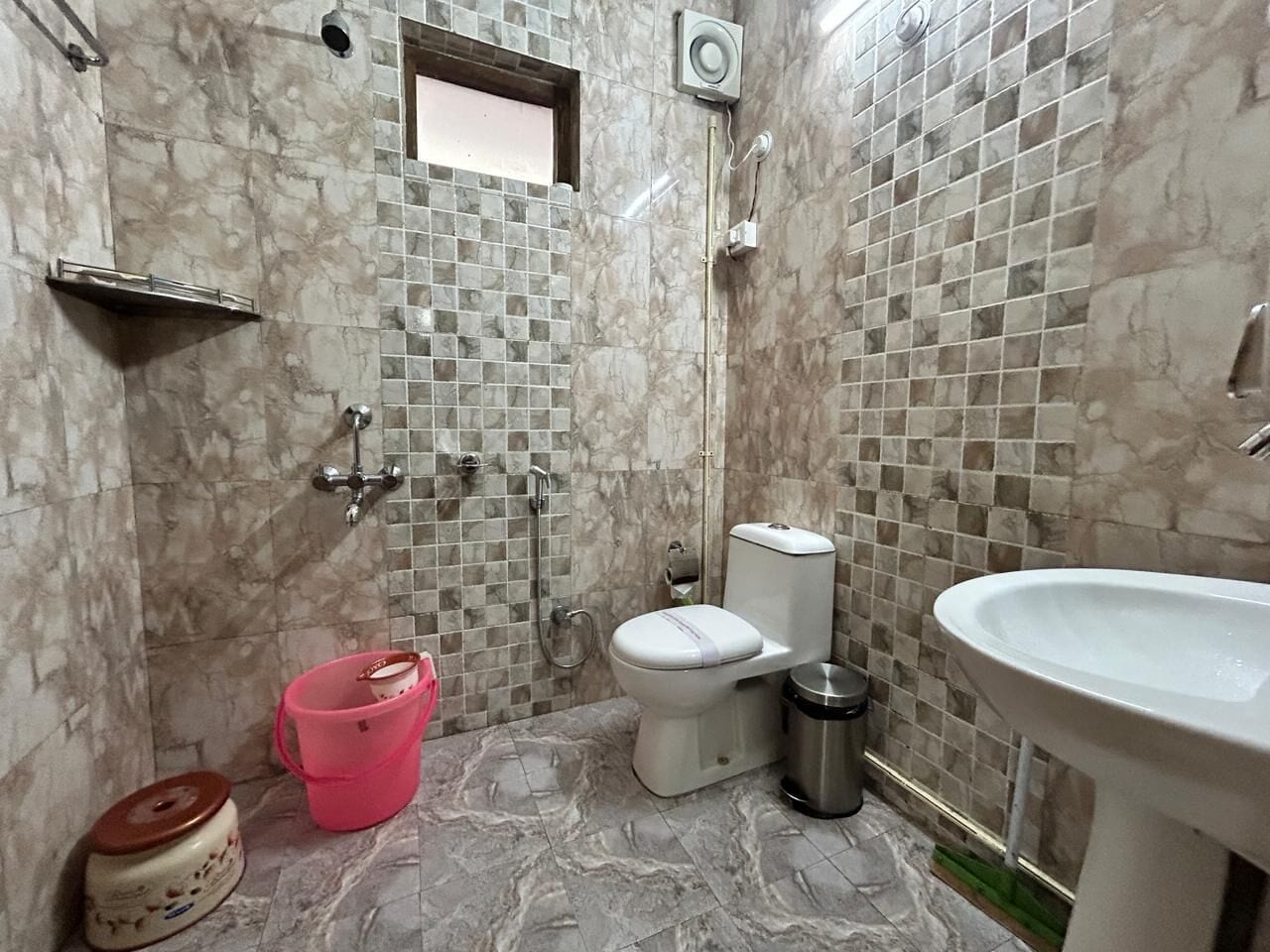 A bathroom with a toilet, sink, and shower.