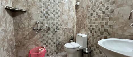A bathroom with a toilet, sink, and shower.