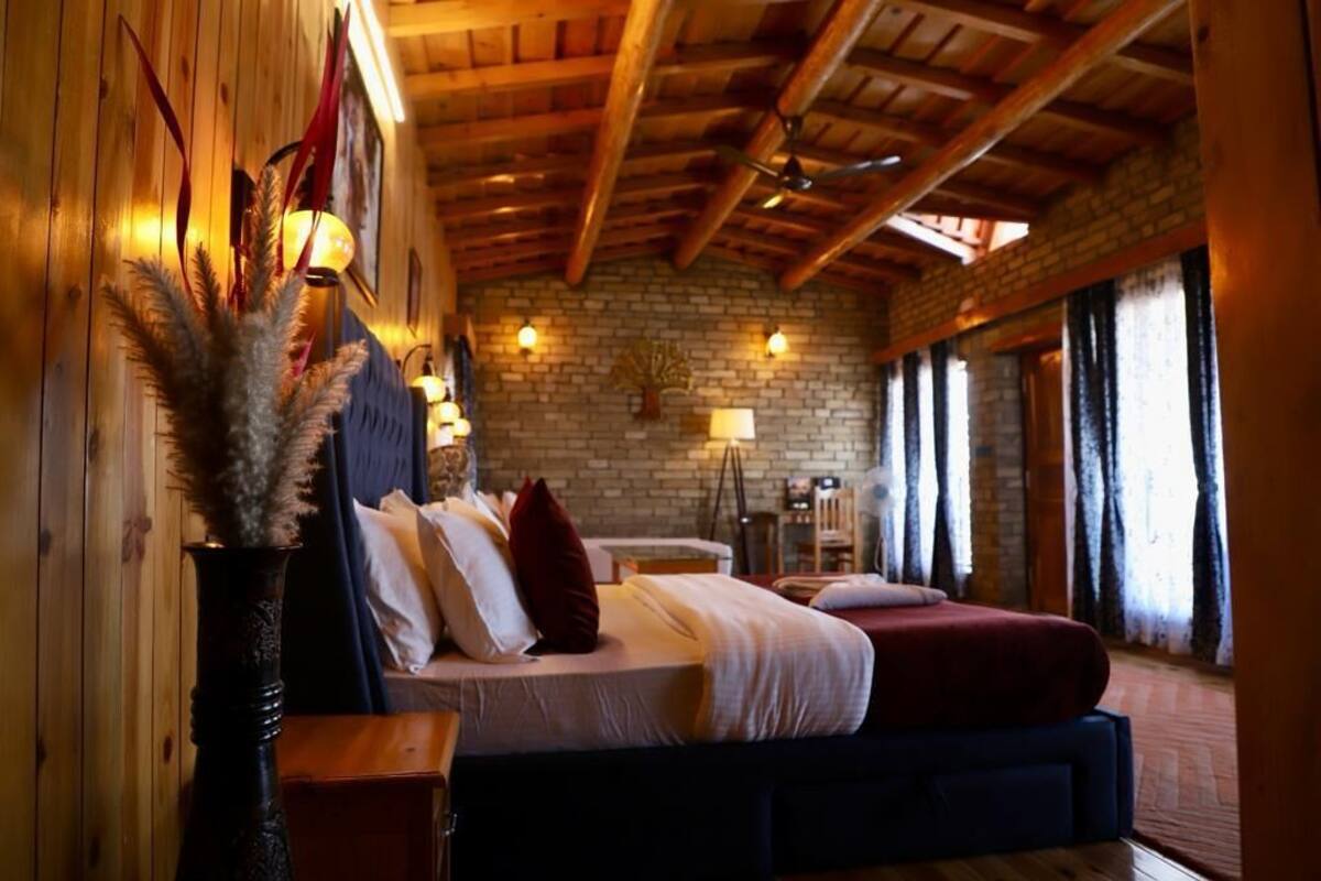 A cozy room with a bed, wooden walls, and a brick wall.