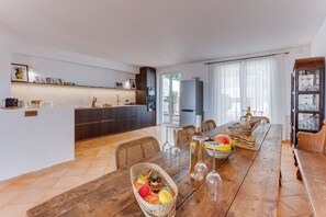 Une cuisine moderne avec un coin repas, comprenant une table en bois, des chaises et un buffet.