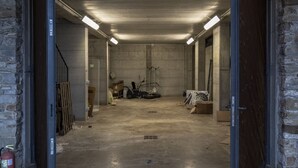 A spacious, unfinished basement with concrete floors and walls, exposed beams, and scattered construction materials. - Villa Cavalieri in Vedriano with a panoramic view of the Reggio Emilia hills (Canossa)