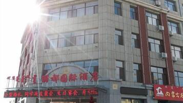 A multi-story building with a prominent sign at the entrance.