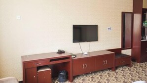 A room with a TV mounted on the wall, a wooden cabinet, and a patterned carpet. - Lidu International Hotel (Ar Horqin Banner)