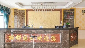A reception desk with a marble top and a large wall mural. - Lidu International Hotel (Ar Horqin Banner)