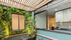 A modern interior with a green wall, wooden ceiling, and a kitchen visible through a window. - Hospedium Apartamentos DV (Barcelona)