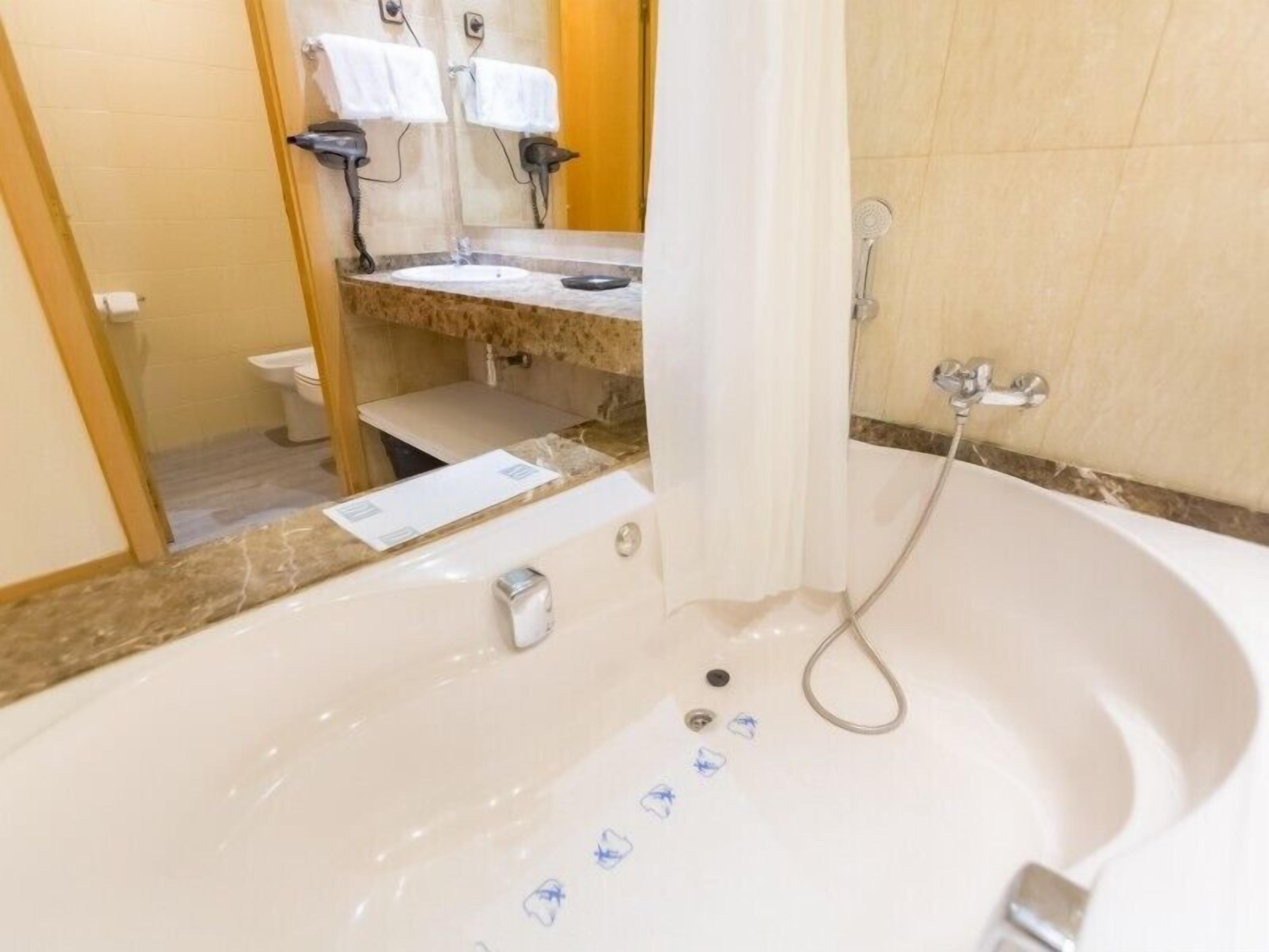 Un baño con bañera, inodoro y lavamanos.
