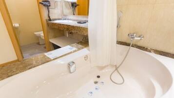 Un baño con bañera, inodoro y lavamanos.