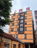 Un edificio de varios pisos con un letrero llamativo que muestra el número 99 y caracteres chinos.