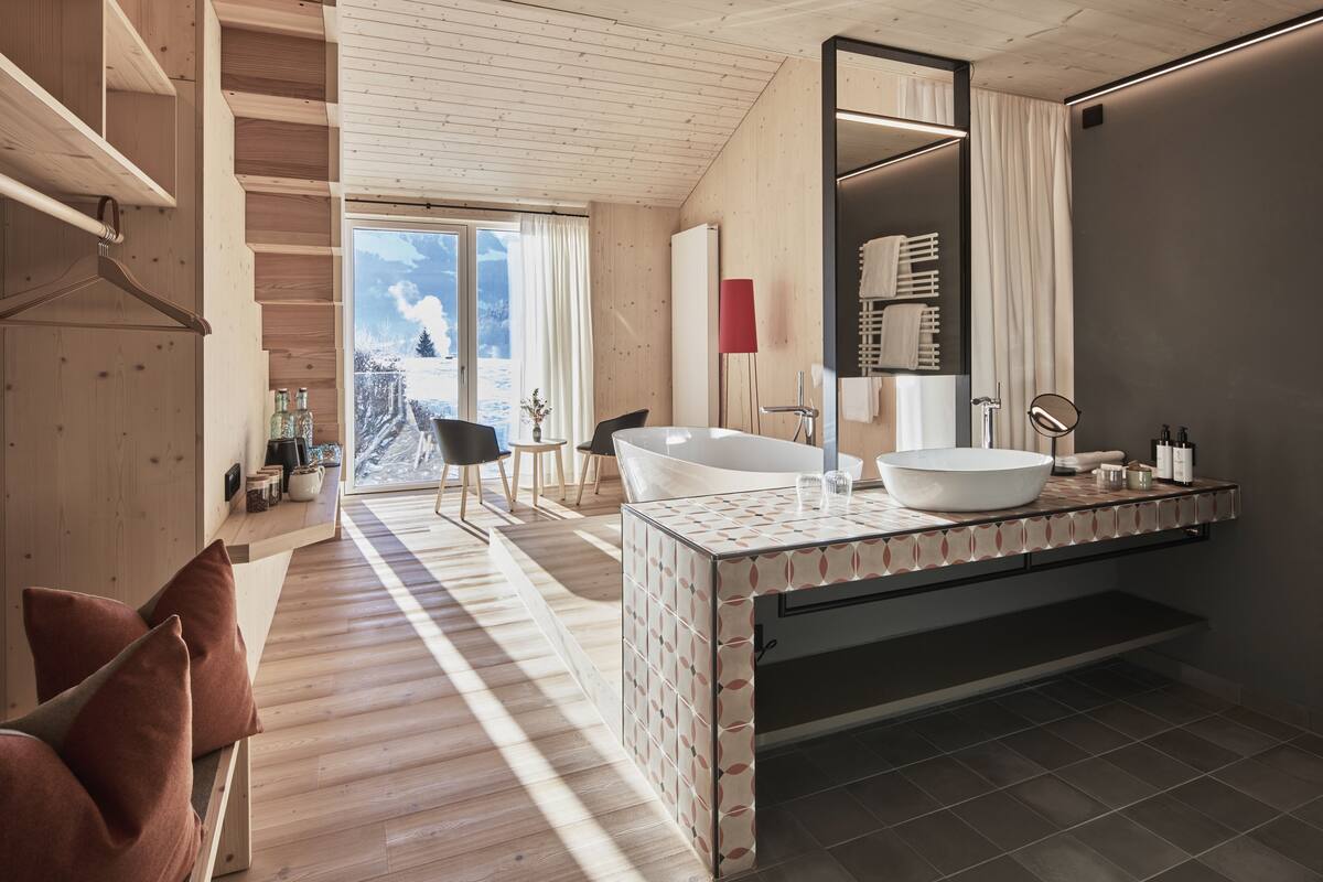 Une salle de bain moderne avec une grande baignoire, un miroir et un plancher en bois.