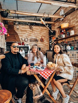 Un comedor rústico con paredes de ladrillo, tuberías a la vista y una variedad de utensilios y adornos de cocina.