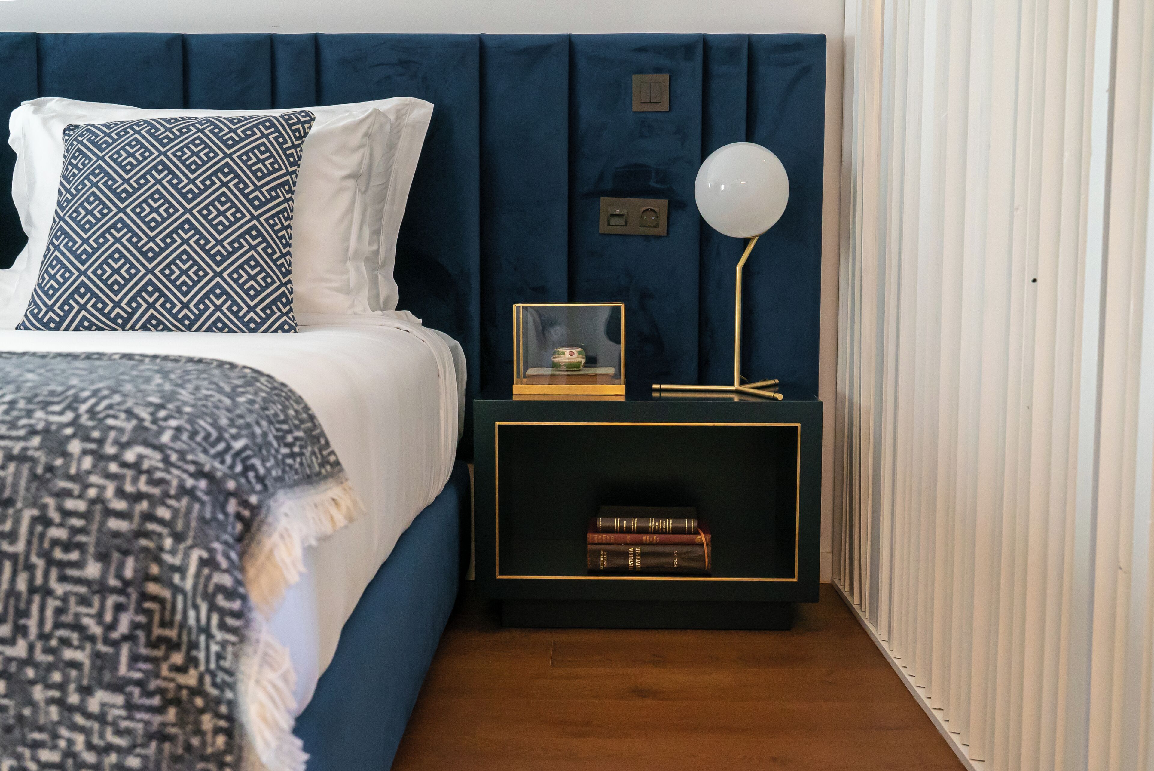 Una camera da letto con un letto, un comodino, una lampada e un quadro incorniciato.