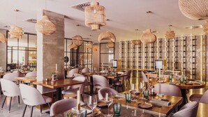 A restaurant with multiple dining tables, chairs, and hanging wicker chandeliers. - Quinta de Silvalde (Santo Tirso)