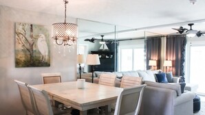 Un salon moderne avec une table à manger, des canapés et un lustre.