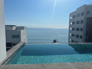 A clear view of a swimming pool with a view of the sea, surrounded by modern buildings. - Beautiful 3 Bed 2 Bath Condo 1/2 a block to the beach. 5 min to Bucerias Centro (Bucerías)