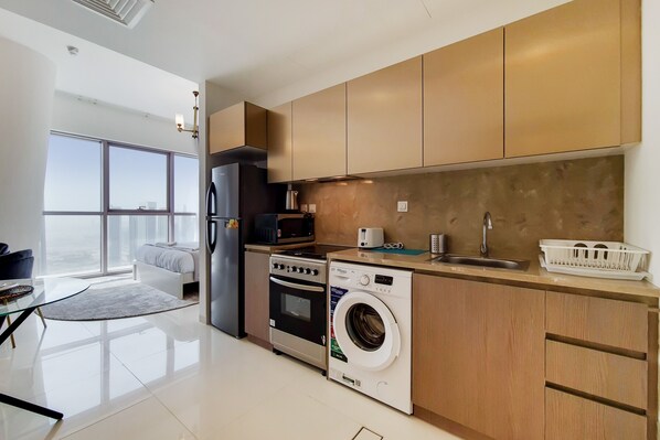 Una cocina moderna con electrodomésticos de acero inoxidable, armarios de madera y un amplio ventanal con vistas a la ciudad.