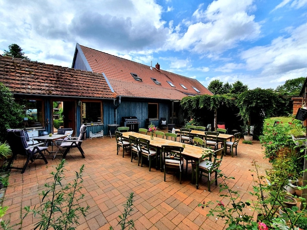 Un patio con mobiliario exterior y una parrilla.