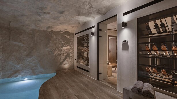 A spa area with a wooden floor, a stone wall, and a wine rack.