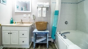 A bathroom with a sink, mirror, towel rack, and shower. - Jacuzzi room - 2 Queen beds (OGUNQUIT)