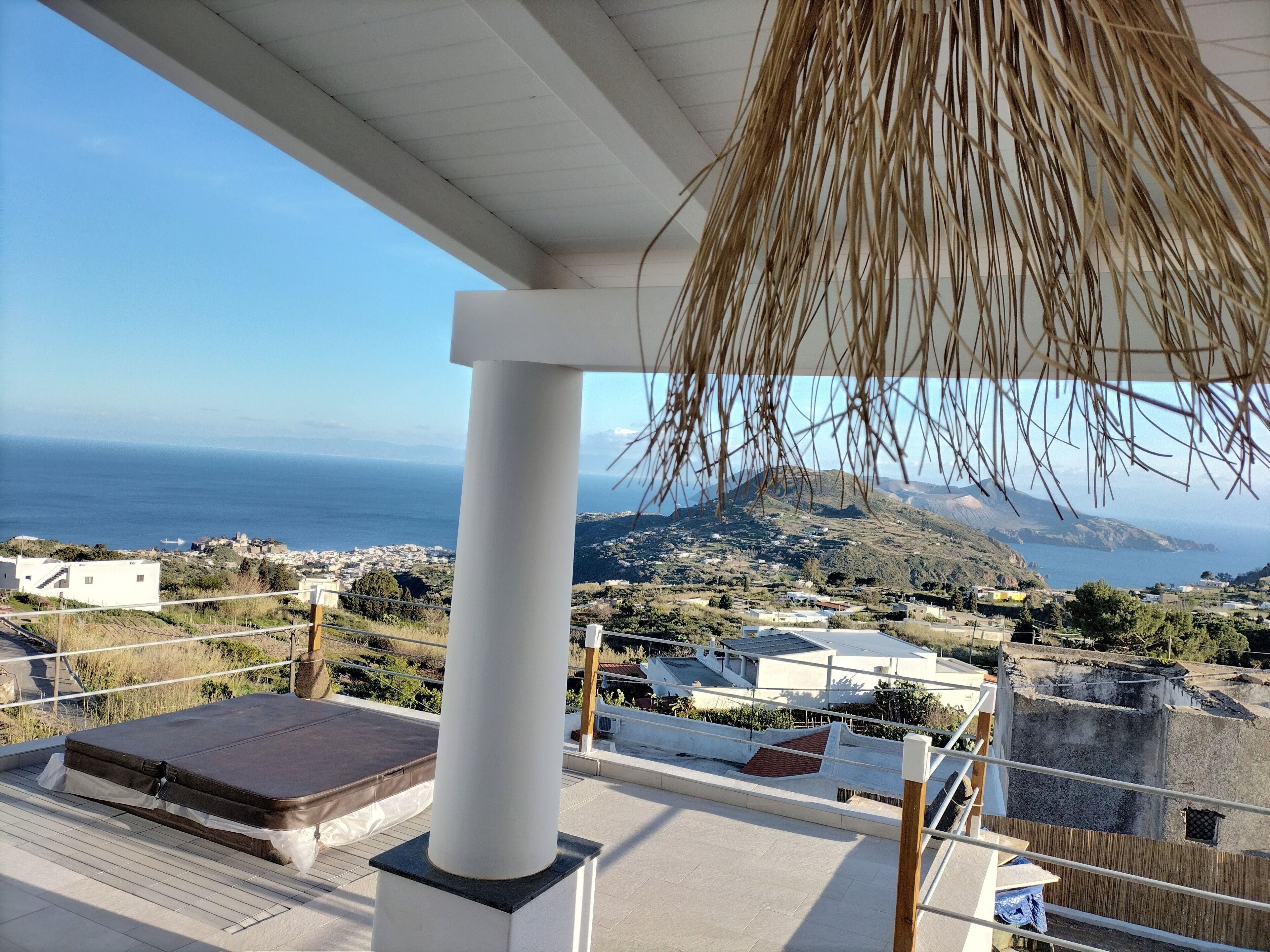 Un balcon avec vue sur la mer et sur une montagne.