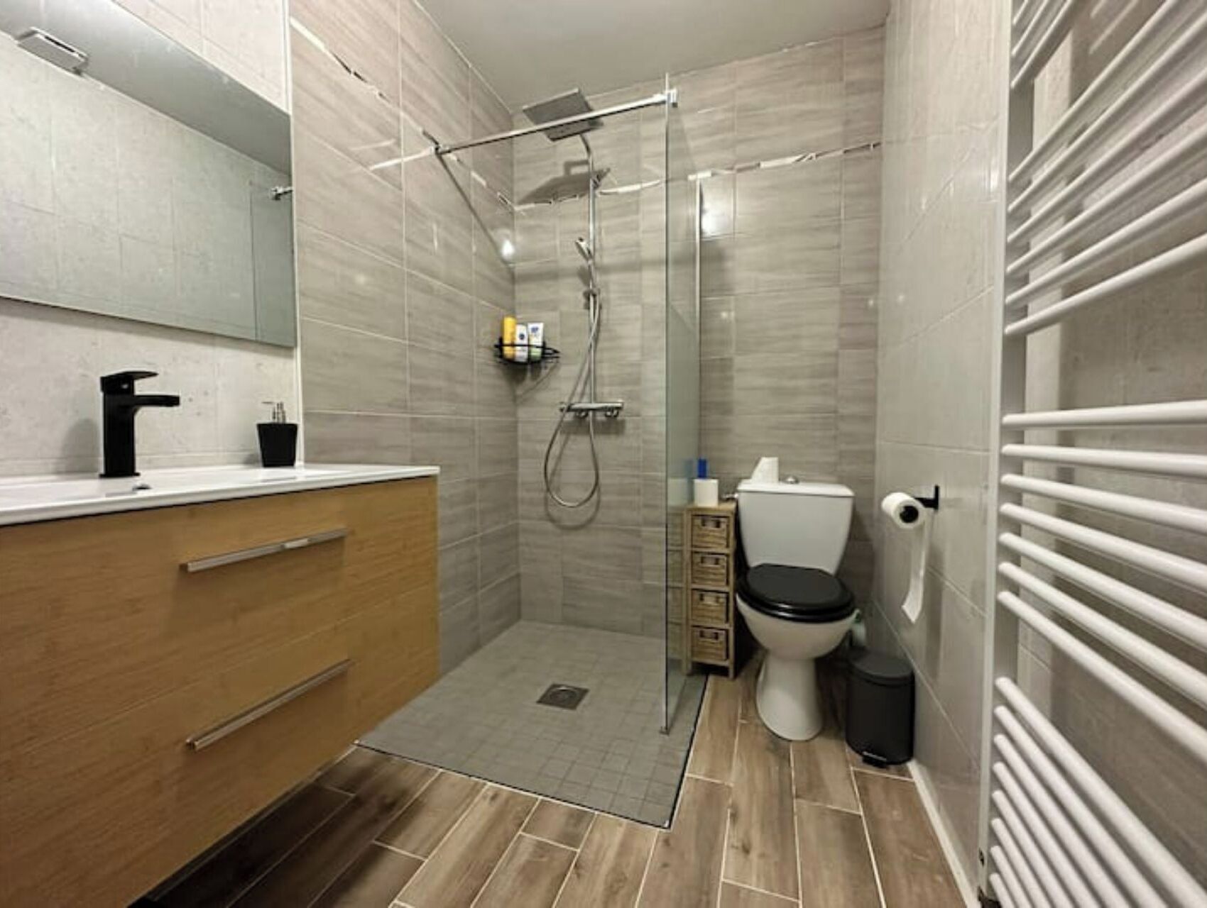 Een moderne badkamer met een douche, toilet en wastafel.