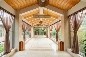 A corridor with a high ceiling, large windows, and curtains. - Shanghe Hotspring Hotel (Shanghe)