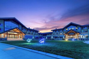 A building with a modern architectural style, featuring a large entrance and a well-maintained lawn area. - Shanghe Hotspring Hotel (Shanghe)