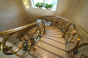 A spiral staircase with ornate metal railings and a handrail. - Shanghe Hotspring Hotel (Shanghe)