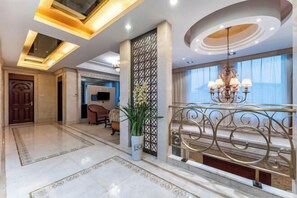 A spacious lobby with a marble floor, a decorative railing, a chandelier, and a large window with curtains. - Shanghe Hotspring Hotel (Shanghe)