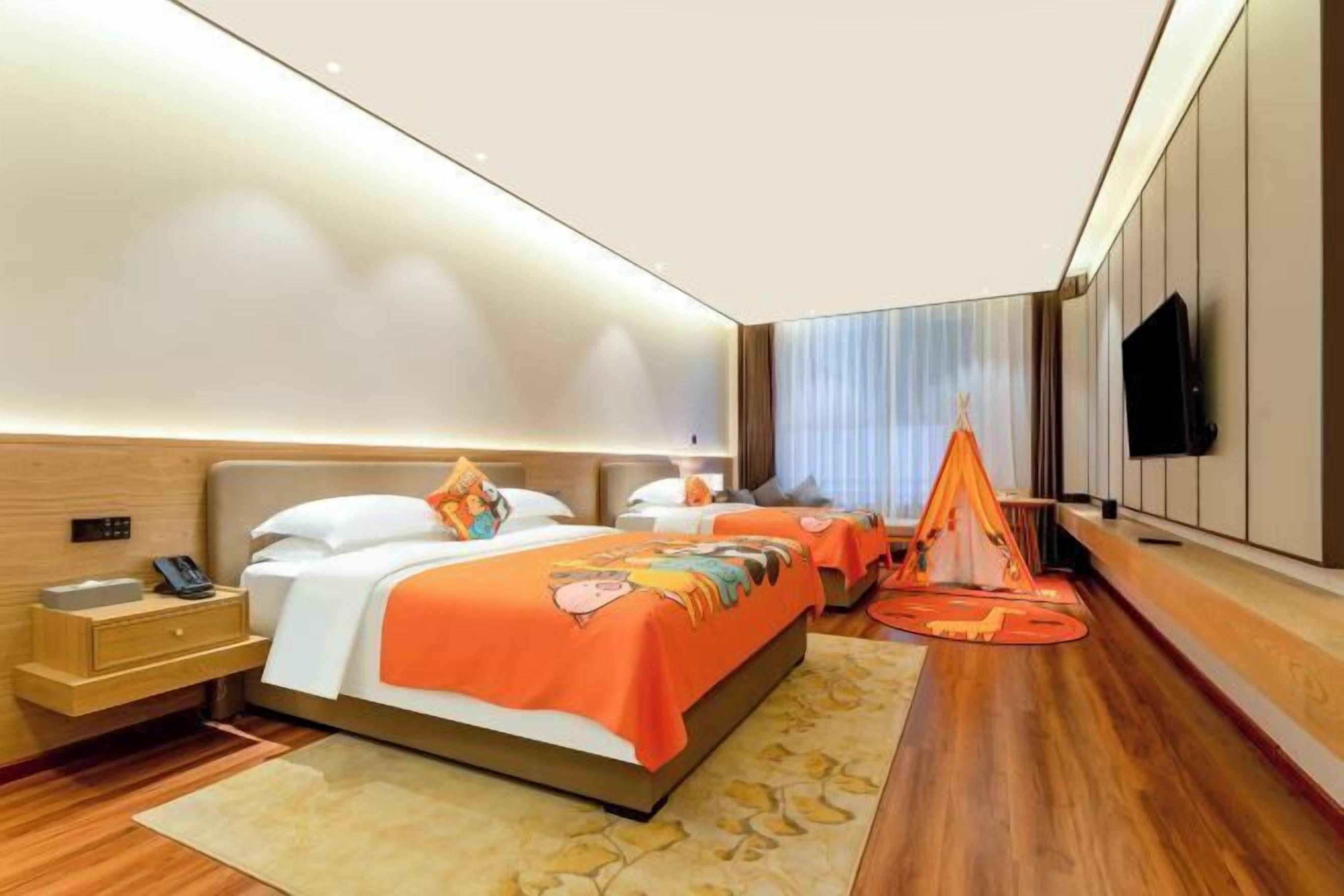 Una habitación de hotel moderna con una cama grande, mesitas de noche, un televisor y una estructura similar a una tienda de campaña.