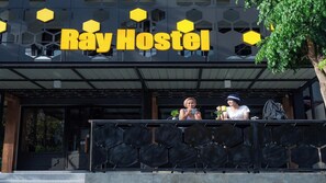 The exterior of Ray Hostel with a modern design, featuring a prominent sign and a balcony area. - Ray Hostel by Zuzu (Chiang Mai)