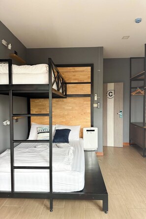 A bunk bed room with a wooden headboard, a bedside table, and a wall-mounted heater. - Ray Hostel by Zuzu (Chiang Mai)