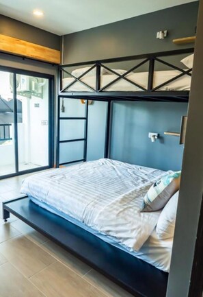 A modern bedroom with a bunk bed, a large window, and a sliding door to a balcony. - Ray Hostel by Zuzu (Chiang Mai)