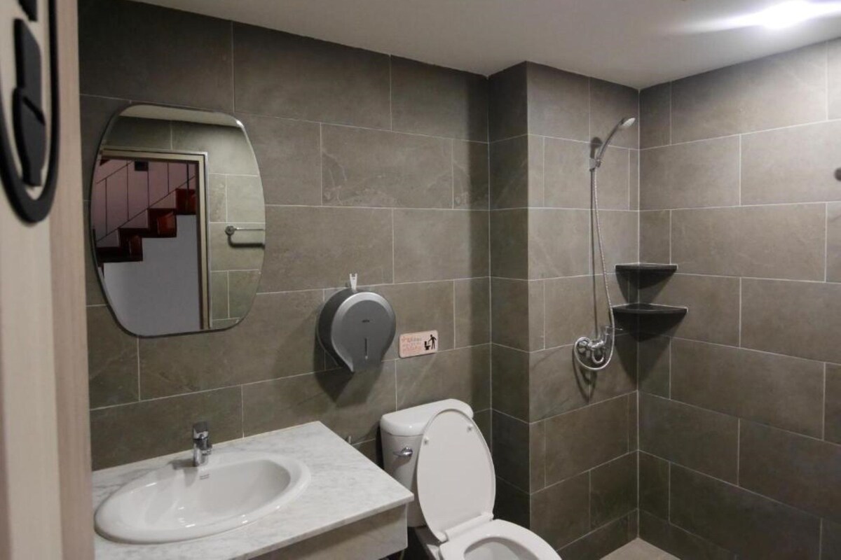 A modern bathroom with a sink, toilet, and shower.