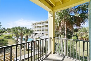 Enjoy the hotel's expansive views from this balcony overlooking the pool and lush surroundings.