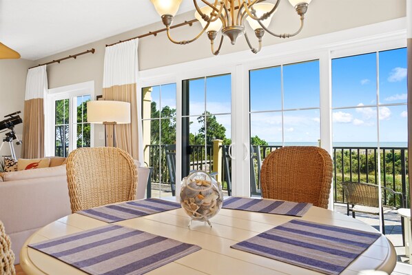 Enjoy a clear view of the outdoors from the large window in this well-appointed room, featuring a round dining table and comfortable seating.
