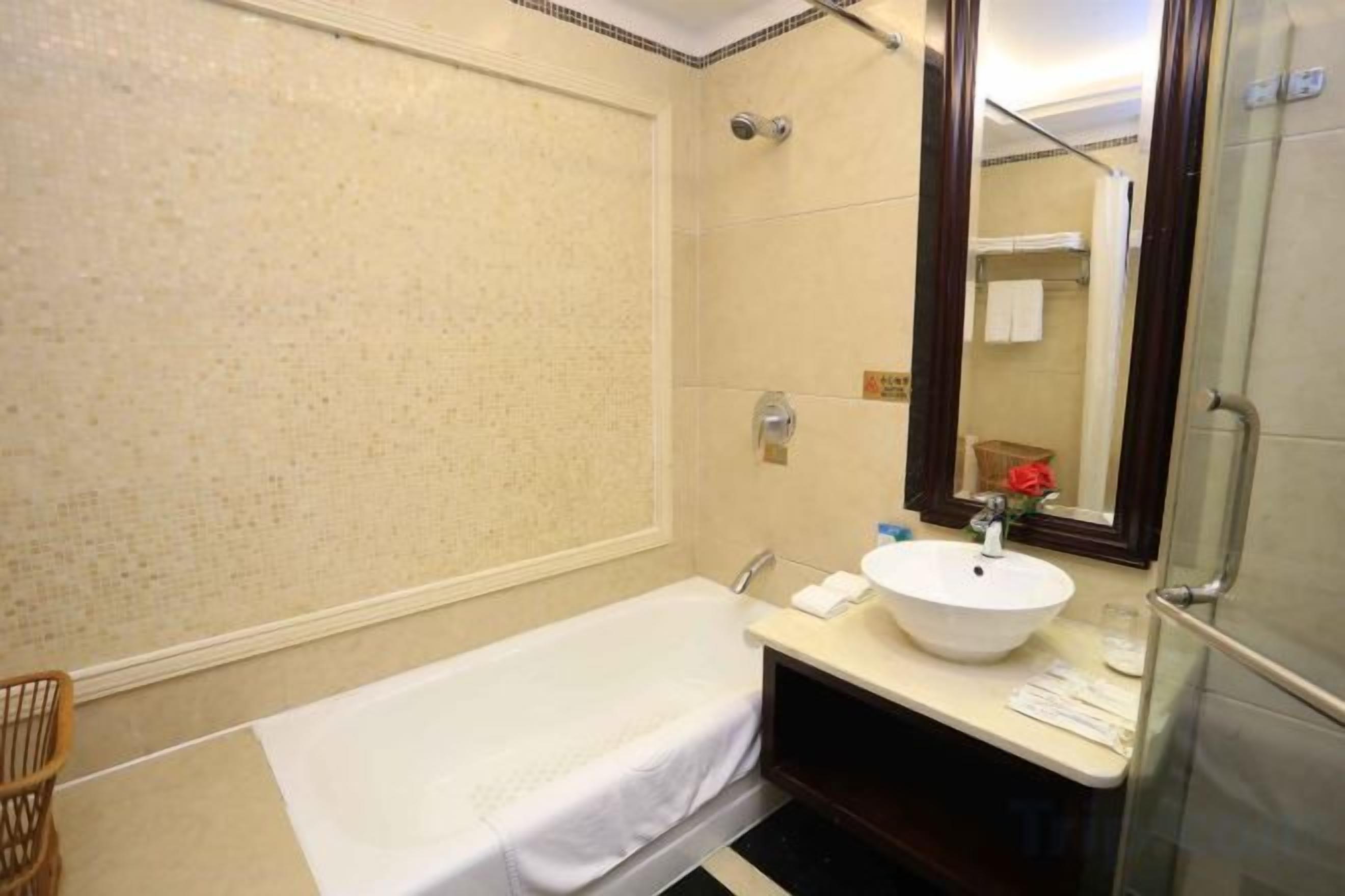 A bathroom with a bathtub, a sink, and a mirror.