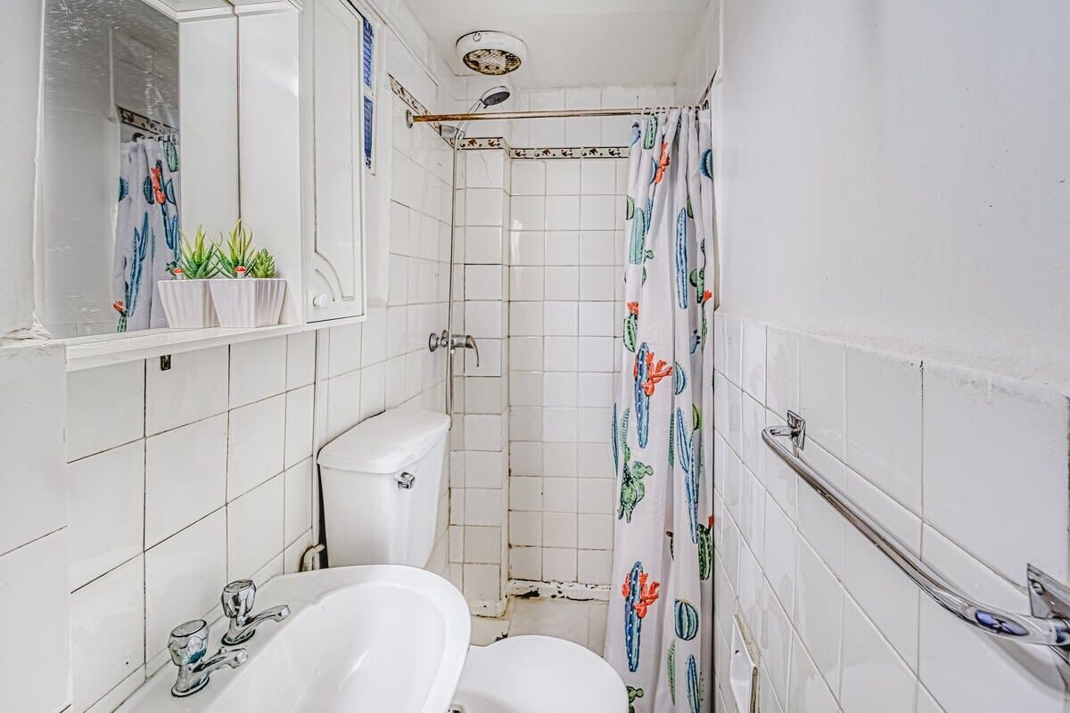 Un baño pequeño y funcional con inodoro, lavamanos y ducha.