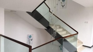 A modern staircase with glass railings and a wooden handrail. - Lishuiwan Hotel (Luoping)